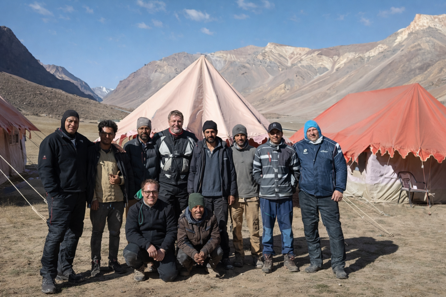 Adventure travelers at Sarchu basecamp with a panoramic view of the Himalayan mountain range.