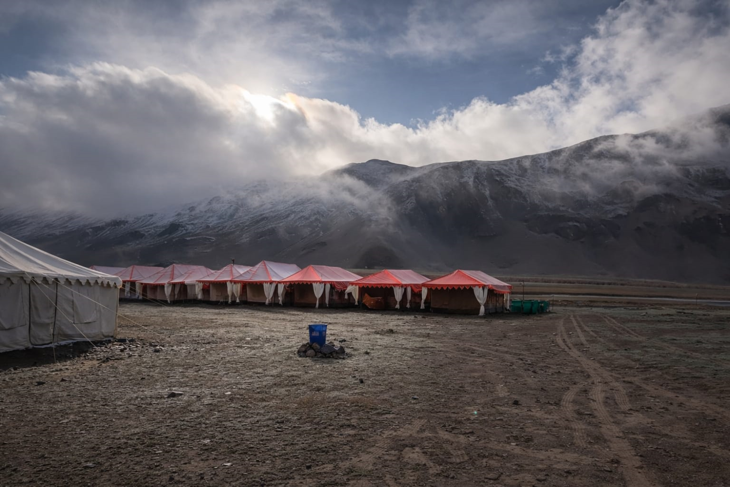 landscape view of a luxury tent colony in Sarchu plains on the Manali-Leh highway, surrounded by the rugged peaks of Lahaul.